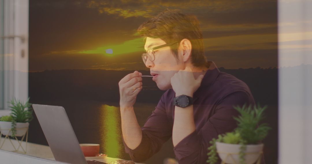 Man Having Snack While Working on Laptop with Sunset in Background - Free Images, Stock Photos and Pictures on Pikwizard.com