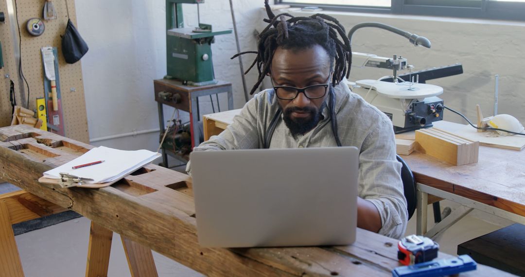 African American Man Using Laptop in Workshop Office - Free Images, Stock Photos and Pictures on Pikwizard.com