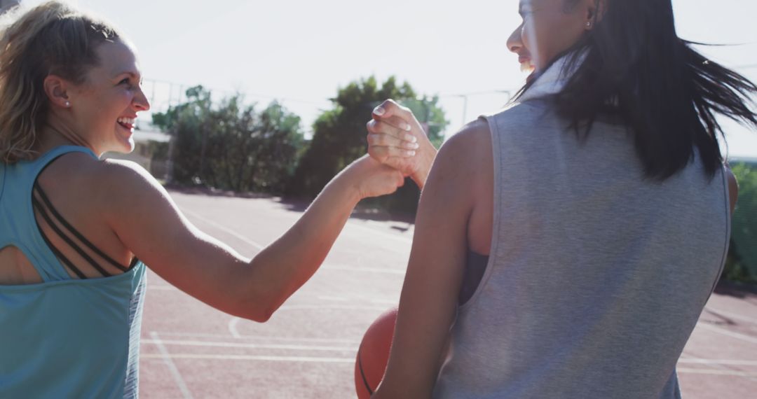 Two Female Athletes Handshaking on Basketball Court in Sunlight - Free Images, Stock Photos and Pictures on Pikwizard.com