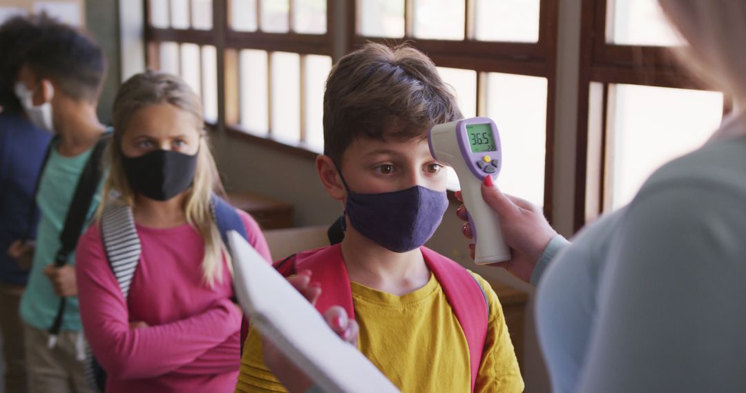 Teacher Checking Students' Temperatures for COVID-19 Safety Compliance