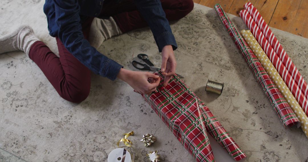 Person Wrapping Christmas Presents on Festive Carpet - Free Images, Stock Photos and Pictures on Pikwizard.com