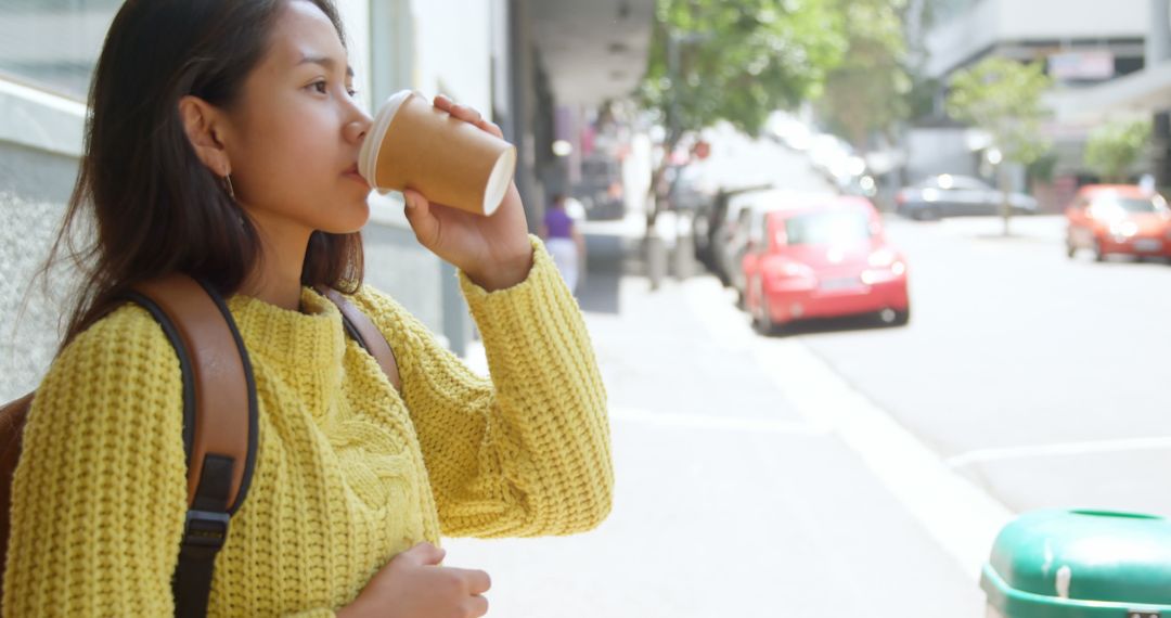 Woman drinking coffee to-go in the city street - Free Images, Stock Photos and Pictures on Pikwizard.com