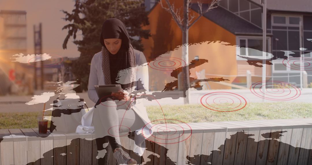 Asian Woman in Hijab Using Tablet Interfaces with Global Map