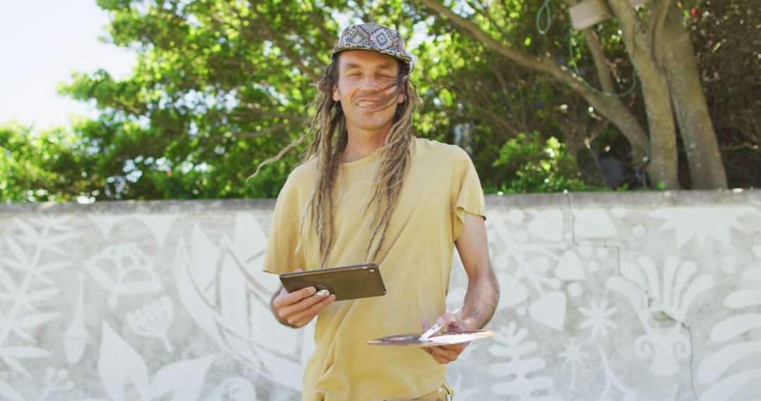 Smiling Man with Tablet and Notepad in Outdoor Setting - Free Images, Stock Photos and Pictures on Pikwizard.com