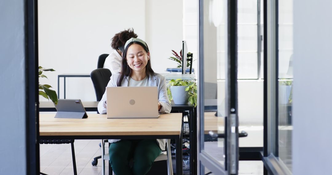 Smiling Businesswoman Using Laptop in Modern Office Environment