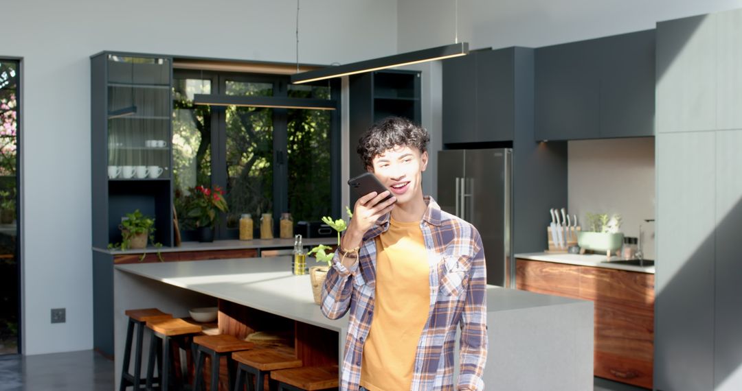 Asian Man Using Smartphone in Modern Kitchen Interior