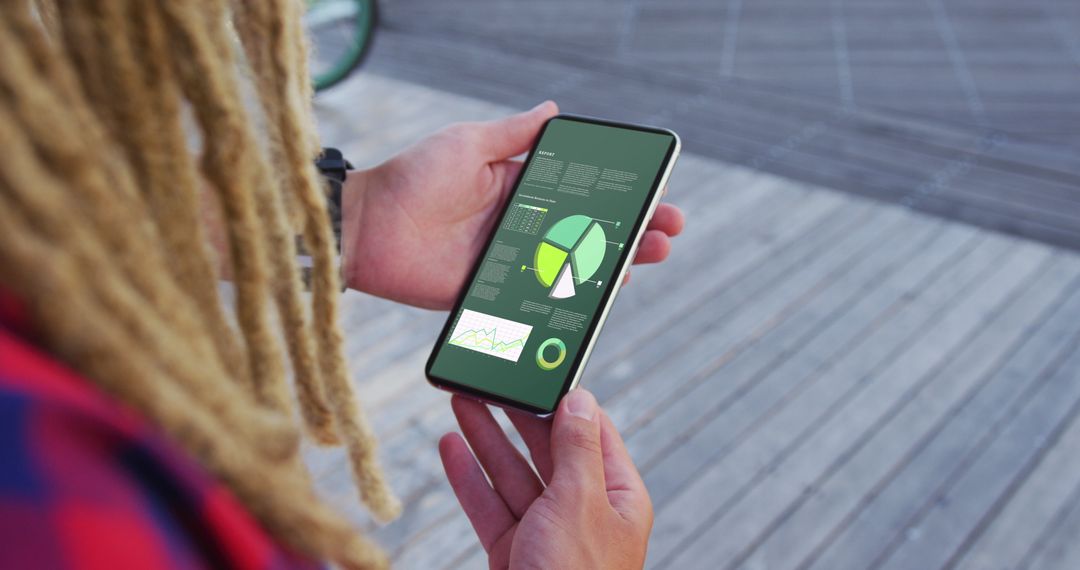 Man Analyzing Digital Statistics on Smartphone Outdoors