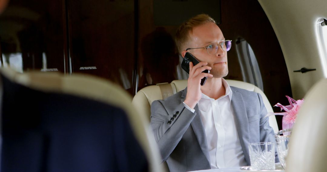 Businessman talking on mobile phone in private jet - Free Images, Stock Photos and Pictures on Pikwizard.com