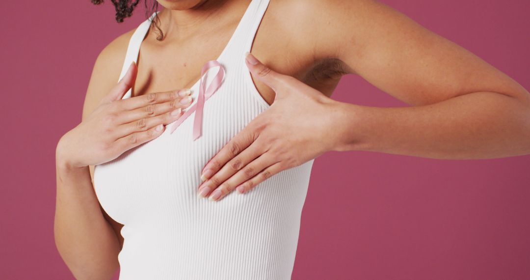 Woman Checking Breast for Lumps Wearing Pink Ribbon - Free Images, Stock Photos and Pictures on Pikwizard.com