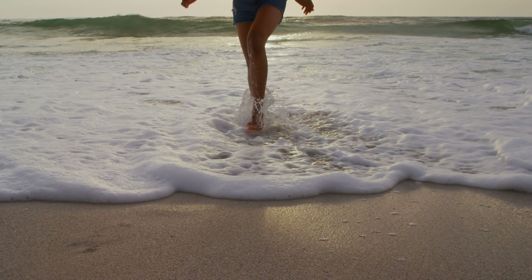 Woman Running on Sunlit Beach with Ocean Waves