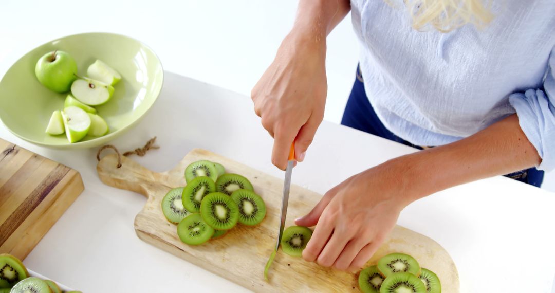 Woman Slicing Fresh Kiwis and Apples on Wooden Cutting Board - Free Images, Stock Photos and Pictures on Pikwizard.com