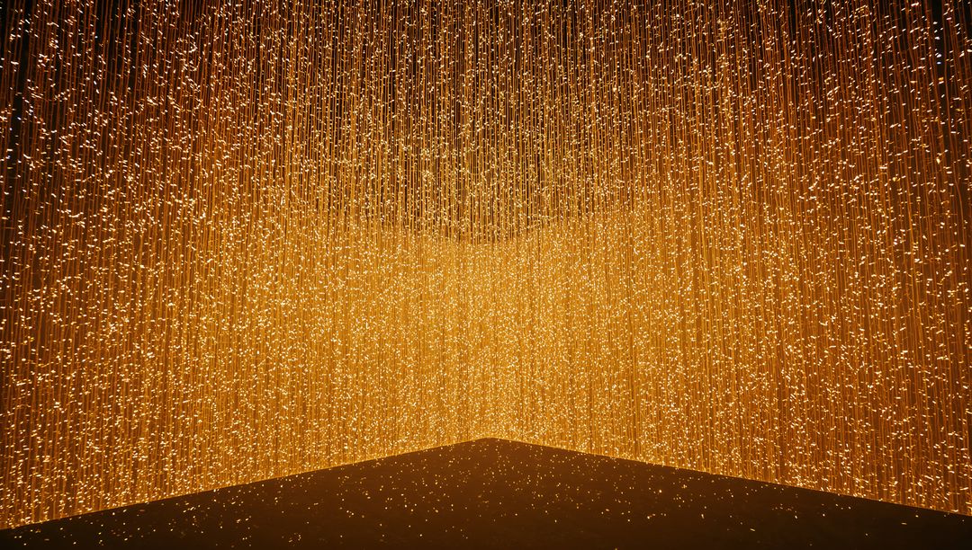 Hanging Golden LED Strands Creating V-Shaped Glow in Gallery Corner