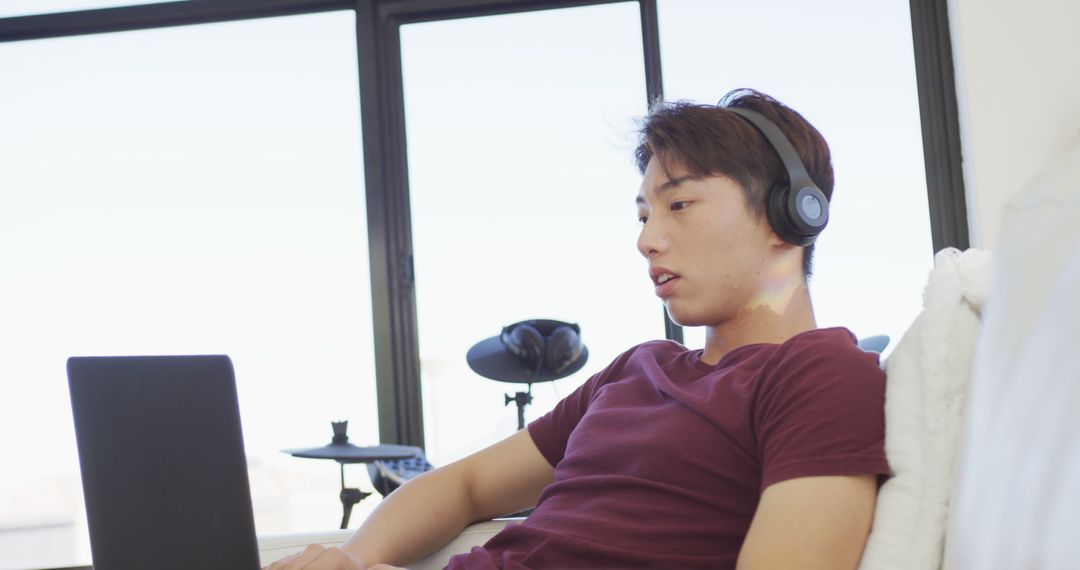 Relaxed Young Man Listening to Music Wearing Headphones at Home - Free Images, Stock Photos and Pictures on Pikwizard.com