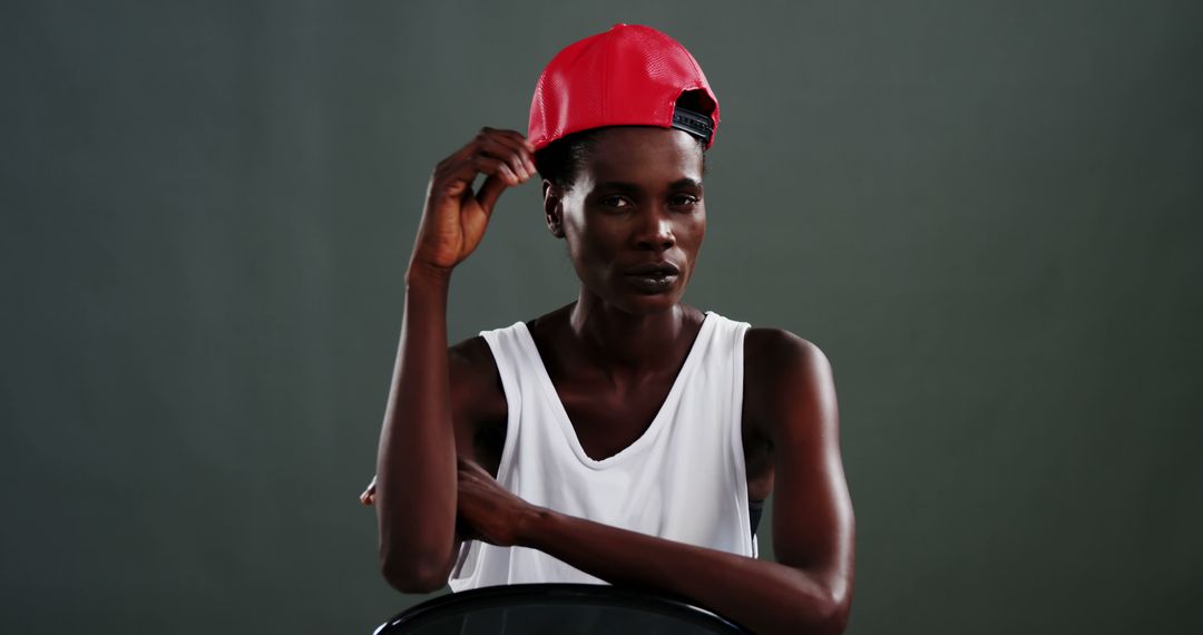An African American man in a white tank top and red cap poses confidently, with copy space - Free Images, Stock Photos and Pictures on Pikwizard.com