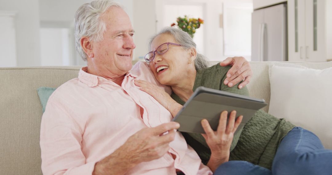 Senior Couple Enjoying Tablet on Couch