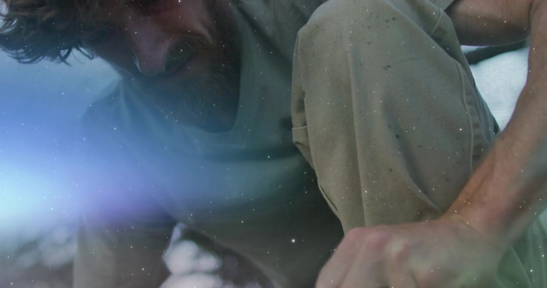 Rugged Man Crouching Outdoors with Lens Flare Atmosphere