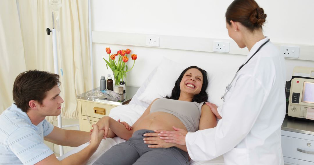 Doctor Examining Pregnant Woman with Partner by Hospital Bed - Free Images, Stock Photos and Pictures on Pikwizard.com