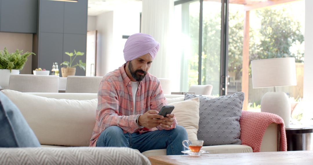 Man in Turban Using Smartphone in Modern Living Room