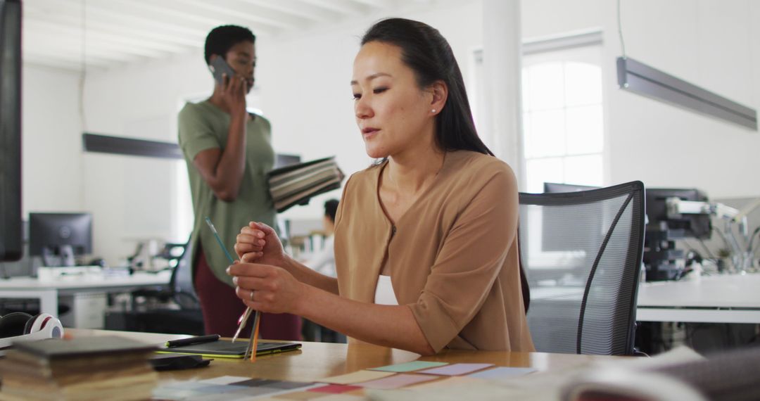 Asian Businesswoman Writing Notes in Modern Office Environment