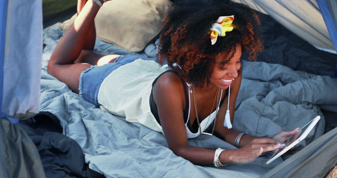 Young Woman Relaxing in Tent Using Digital Tablet During Camping Trip - Free Images, Stock Photos and Pictures on Pikwizard.com