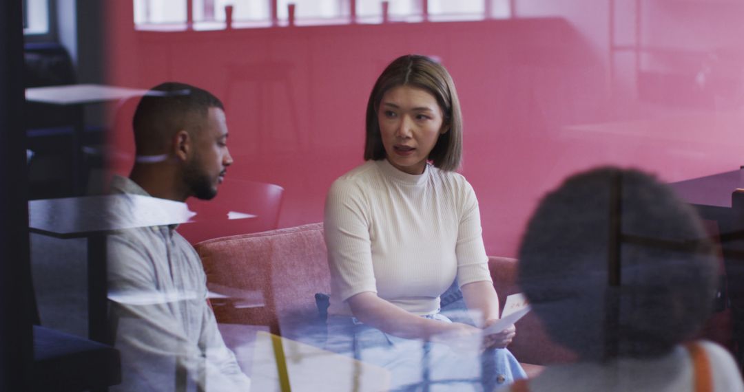 Diverse Professionals Discussing Business Documents in Modern Office