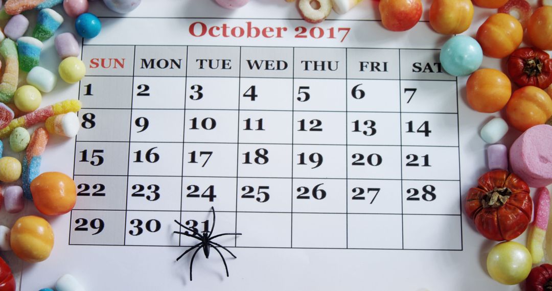 A 2017 October calendar amidst Halloween treats and decor highlights seasonal festivities. - Free Images, Stock Photos and Pictures on Pikwizard.com