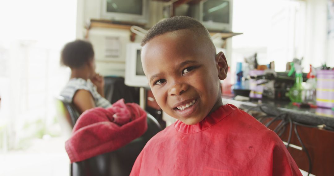 Smiling Boy at Barbershop with Red Cape - Free Images, Stock Photos and Pictures on Pikwizard.com