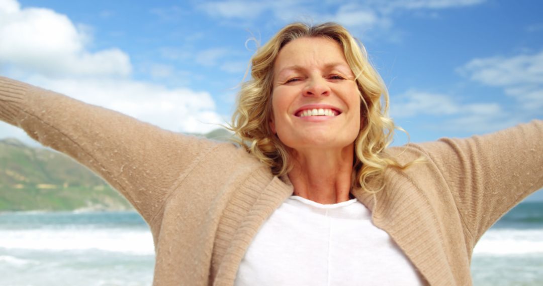 Smiling Woman Enjoying Sunny Beach with Open Arms - Free Images, Stock Photos and Pictures on Pikwizard.com