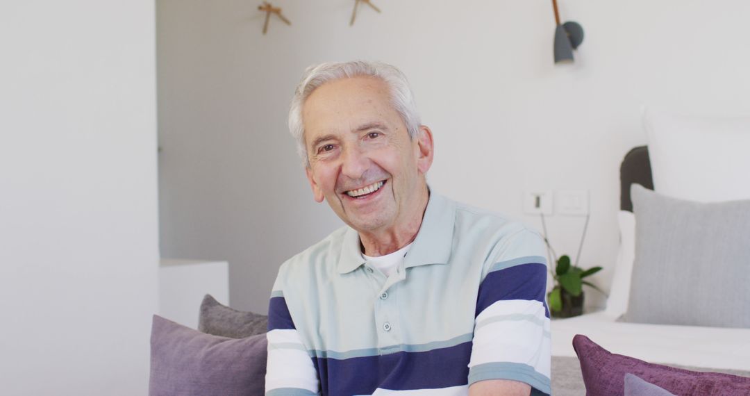 Smiling Elderly Man Sitting in Modern Living Room - Free Images, Stock Photos and Pictures on Pikwizard.com