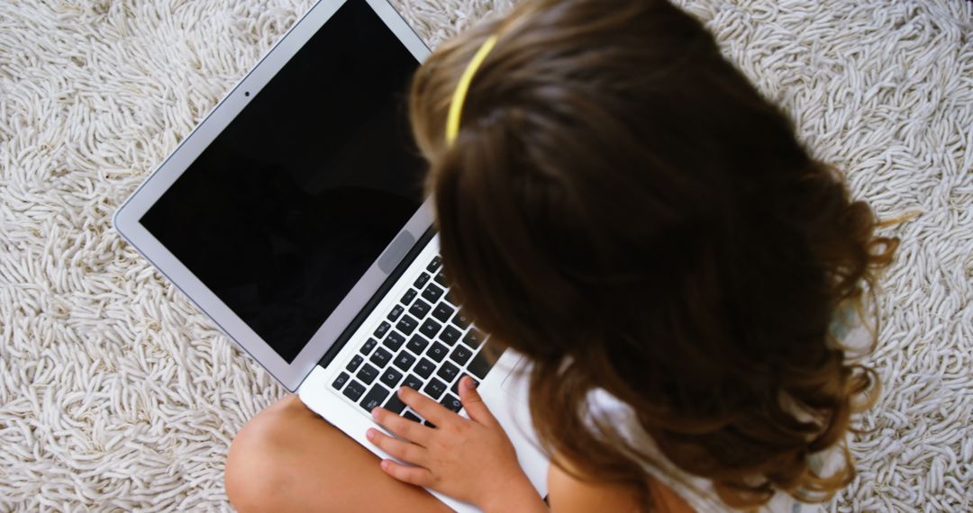 Child Using Laptop Sitting on Carpet, Top View - Free Images, Stock Photos and Pictures on Pikwizard.com