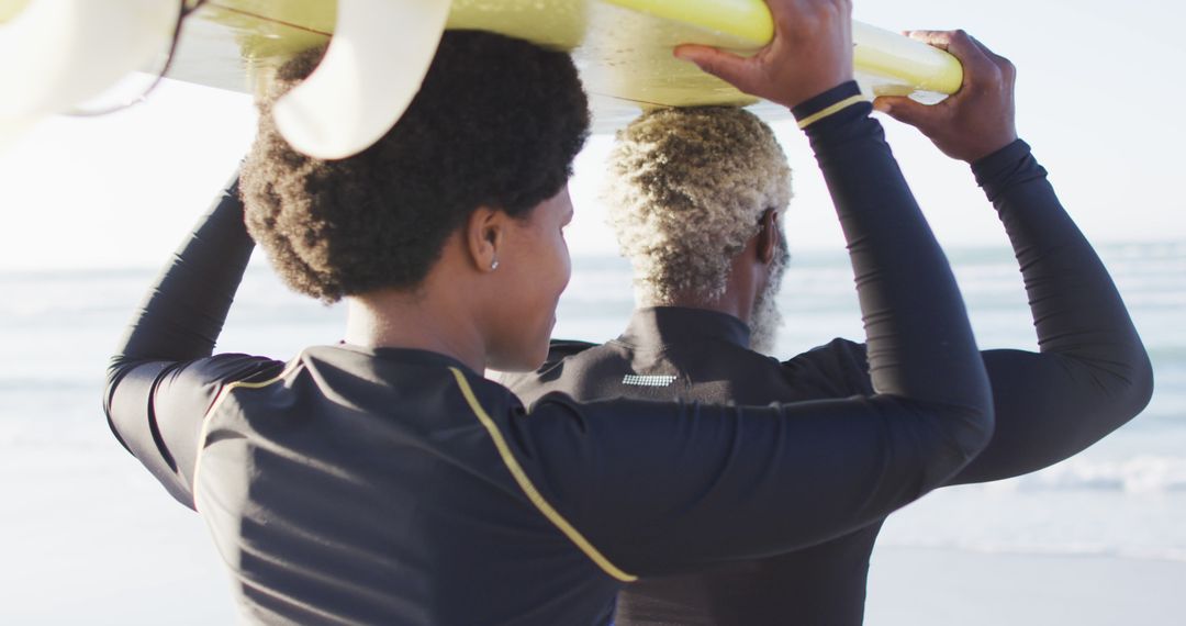 African American surfers carrying surfboard at beach - Free Images, Stock Photos and Pictures on Pikwizard.com