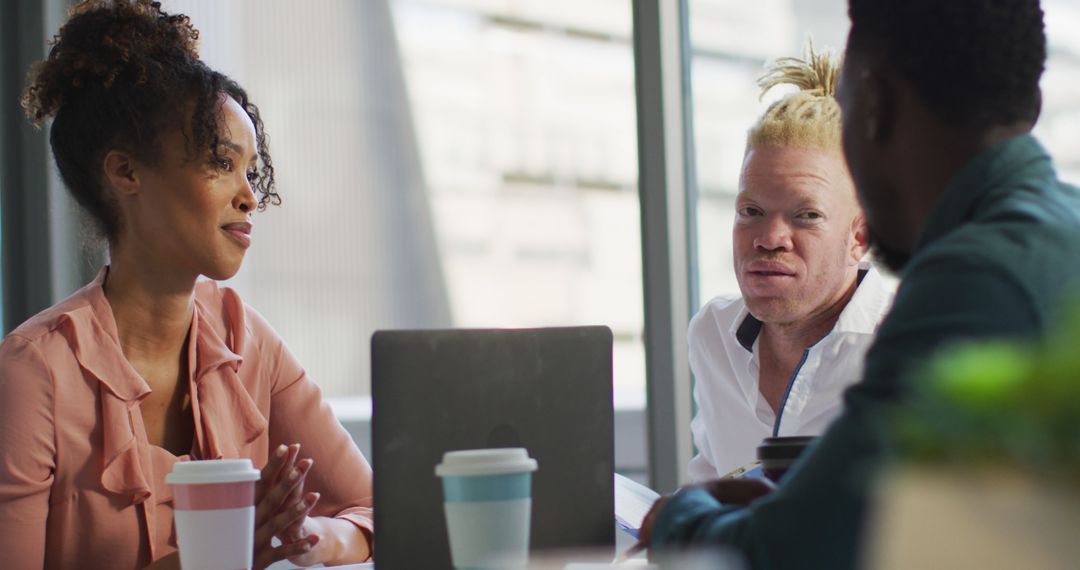 Diverse Team Collaborating Over Takeaway Coffee in Modern Office