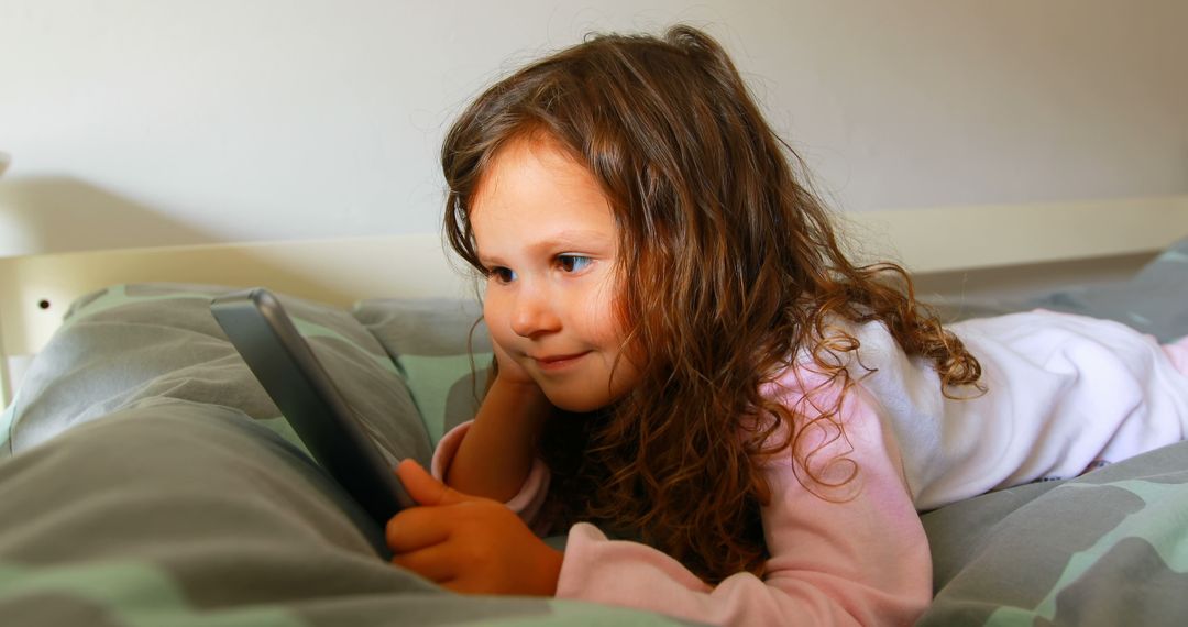 Young Girl Engaged with Tablet While Relaxing on Bed - Free Images, Stock Photos and Pictures on Pikwizard.com