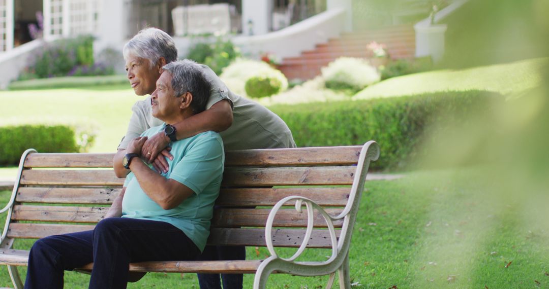 Image of happy biracial senior couple embracing and sitting on bench in garden - Free Images, Stock Photos and Pictures on Pikwizard.com