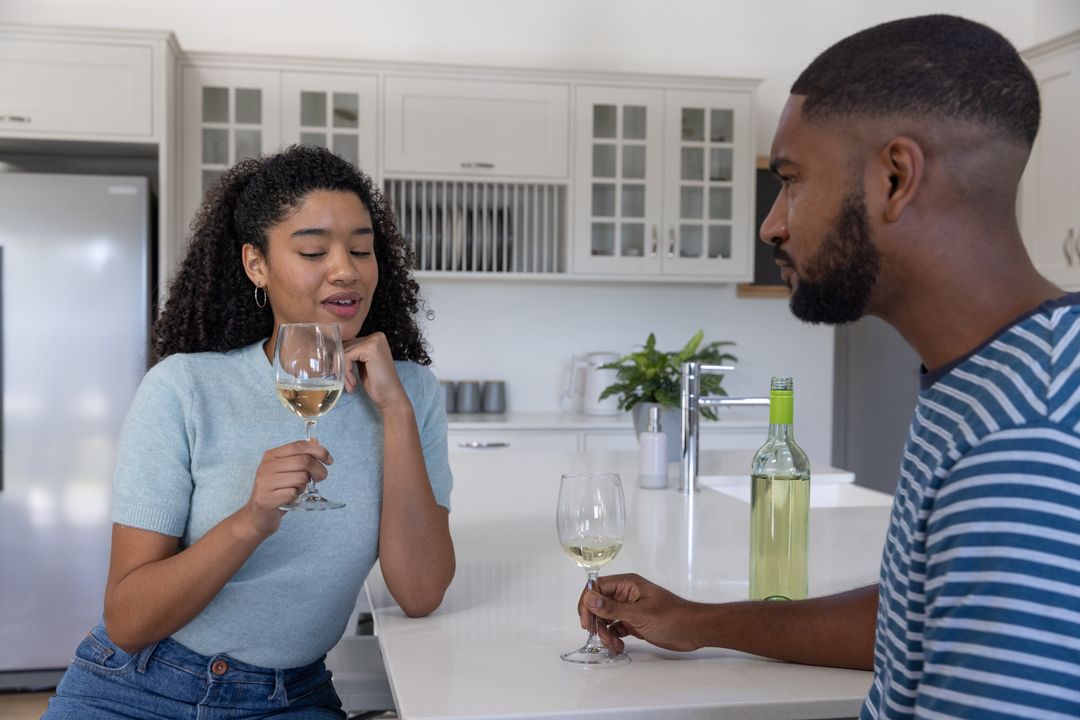 Couple Enjoying Wine and Conversation in Modern Kitchen Setting