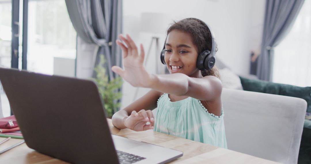 Smiling Young Girl Wearing Headphones Happy and Waving During Video Call at Home - Free Images, Stock Photos and Pictures on Pikwizard.com