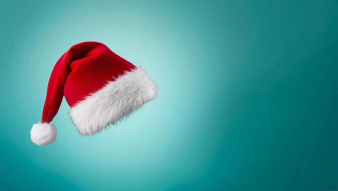 Floating red Santa hat on teal background with white fur trim and pom for holiday mockup
