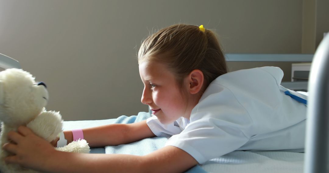 Young Girl in Hospital Bed Interacting with Teddy Bear - Free Images, Stock Photos and Pictures on Pikwizard.com