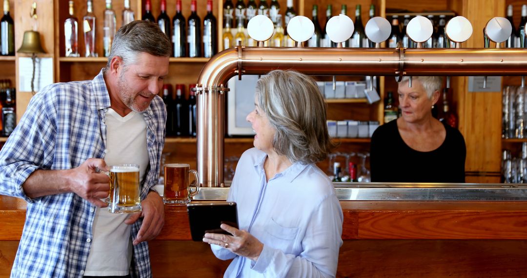 Middle-Aged Couple Socializing at Bar with Bartender Serving