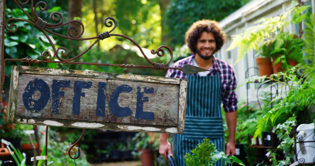 Smiling Gardener in Greenhouse Office with Rustic Sign - Free Images, Stock Photos and Pictures on Pikwizard.com