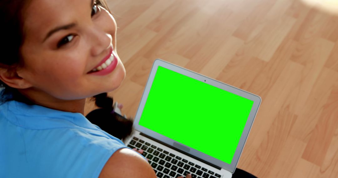 Smiling Woman Using Laptop with Green Screen in Modern Setting - Free Images, Stock Photos and Pictures on Pikwizard.com