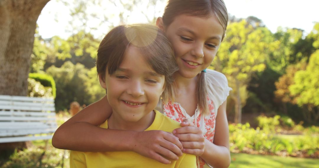 Smiling Children Embracing in Sunny Garden - Free Images, Stock Photos and Pictures on Pikwizard.com