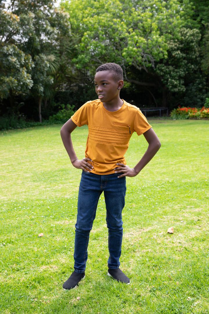 Young Boy Posing Confidently in Park on Sunny Day
