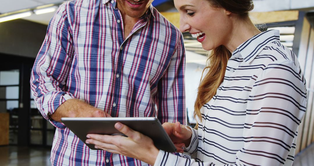 Smiling Colleagues Using Tablet at Modern Office