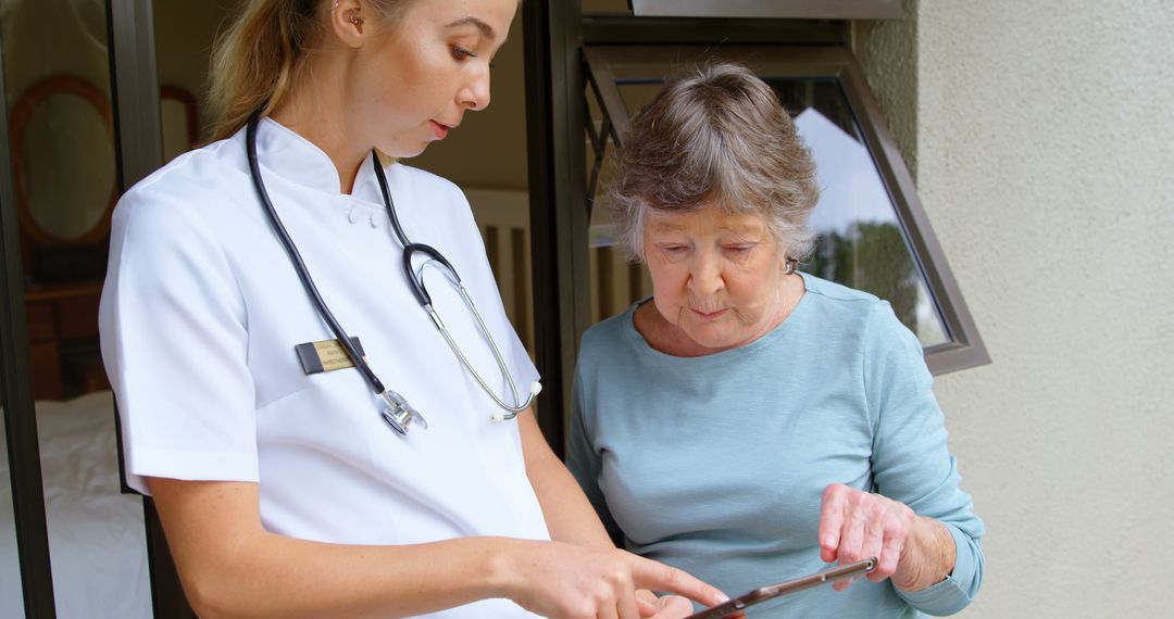 Female Nurse Assisting Elderly Woman with Digital Tablet Outdoors - Free Images, Stock Photos and Pictures on Pikwizard.com