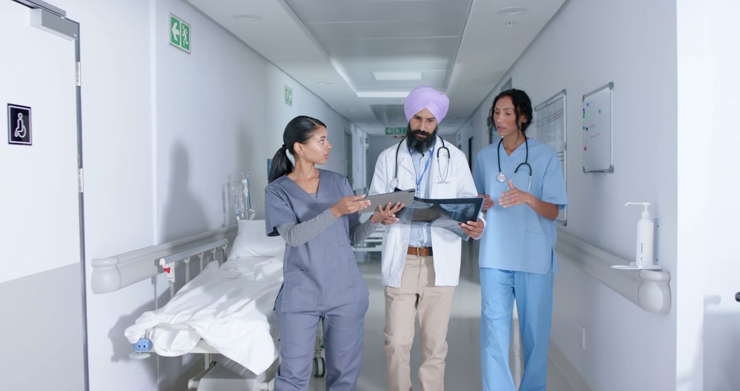 Multicultural Medical Team Analyzing Patient X-Ray in Hospital Corridor - Free Images, Stock Photos and Pictures on Pikwizard.com