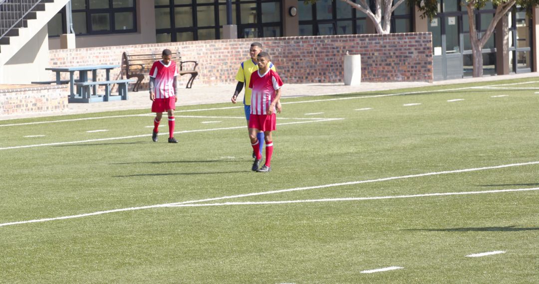 Soccer Players Competing on Field in Colorful Uniforms