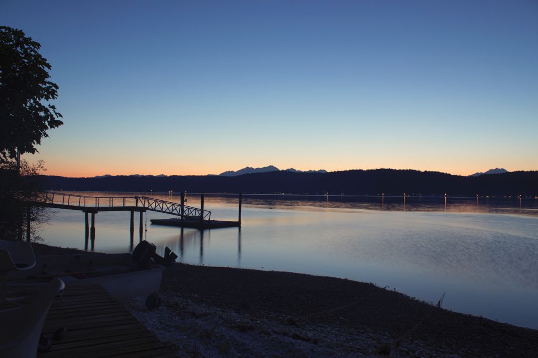 Serene Lake at Dawn with a Wooden Pier and Mountains - Free Images, Stock Photos and Pictures on Pikwizard.com