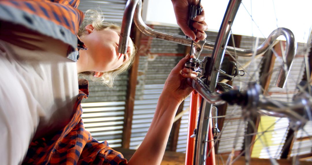 Woman Fixing Bicycle in Garage from Low Angle View - Free Images, Stock Photos and Pictures on Pikwizard.com