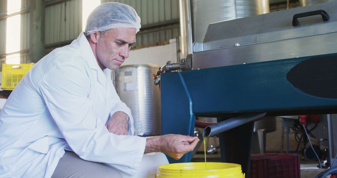 Quality Inspector Examining Liquid Output at Manufacturing Facility - Free Images, Stock Photos and Pictures on Pikwizard.com